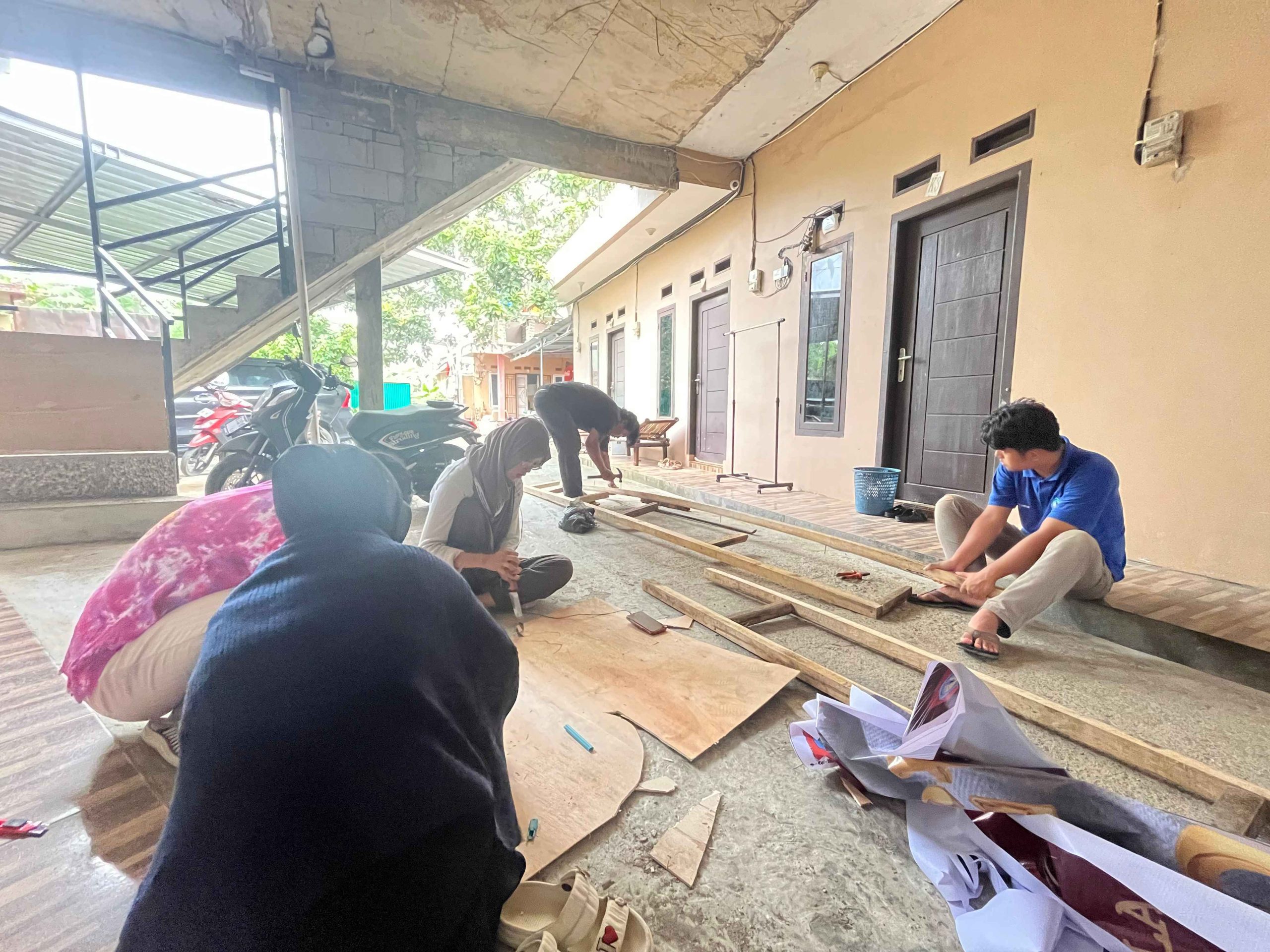 Mahasiswa KKN Kampung Baru bersama warga RT 03 Lingkungan I membuat gapura HUT RI ke-80.