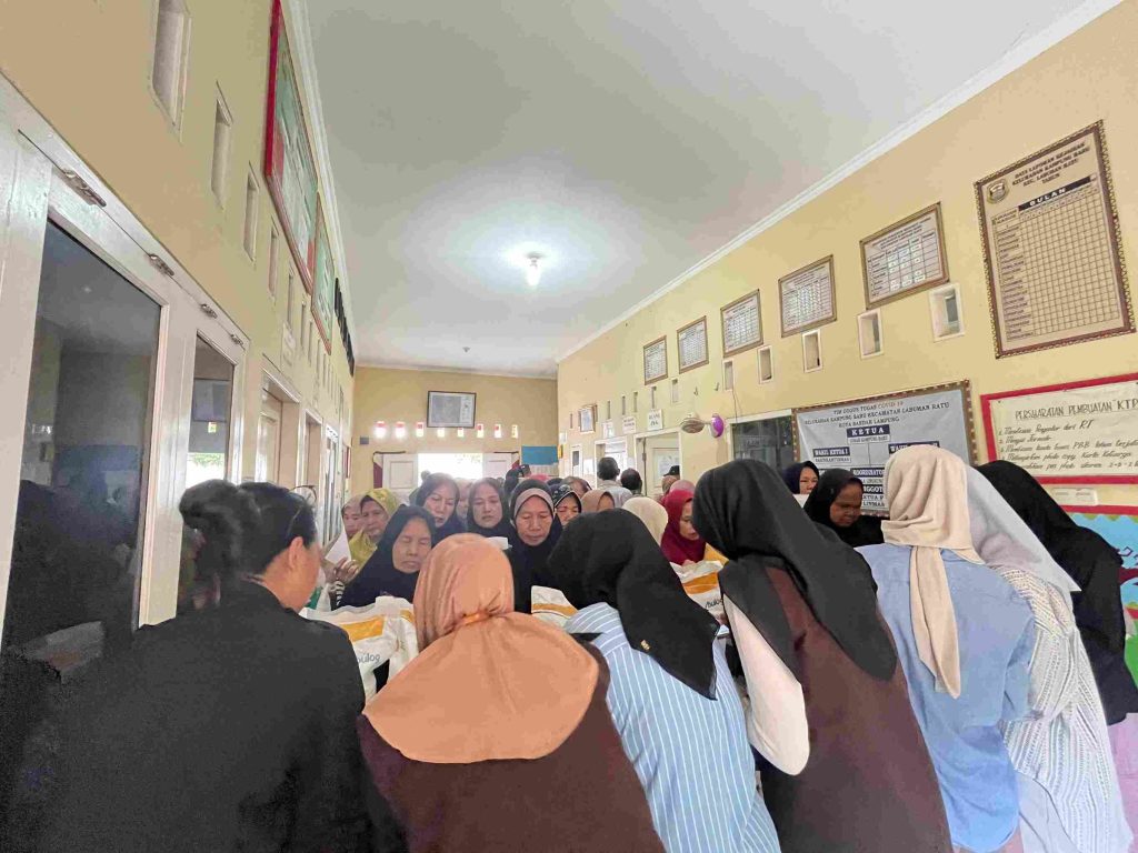 Mahasiswa KKN Kampung Baru membantu perangkat kelurahan dalam pendataan penerima bantuan beras sosial.