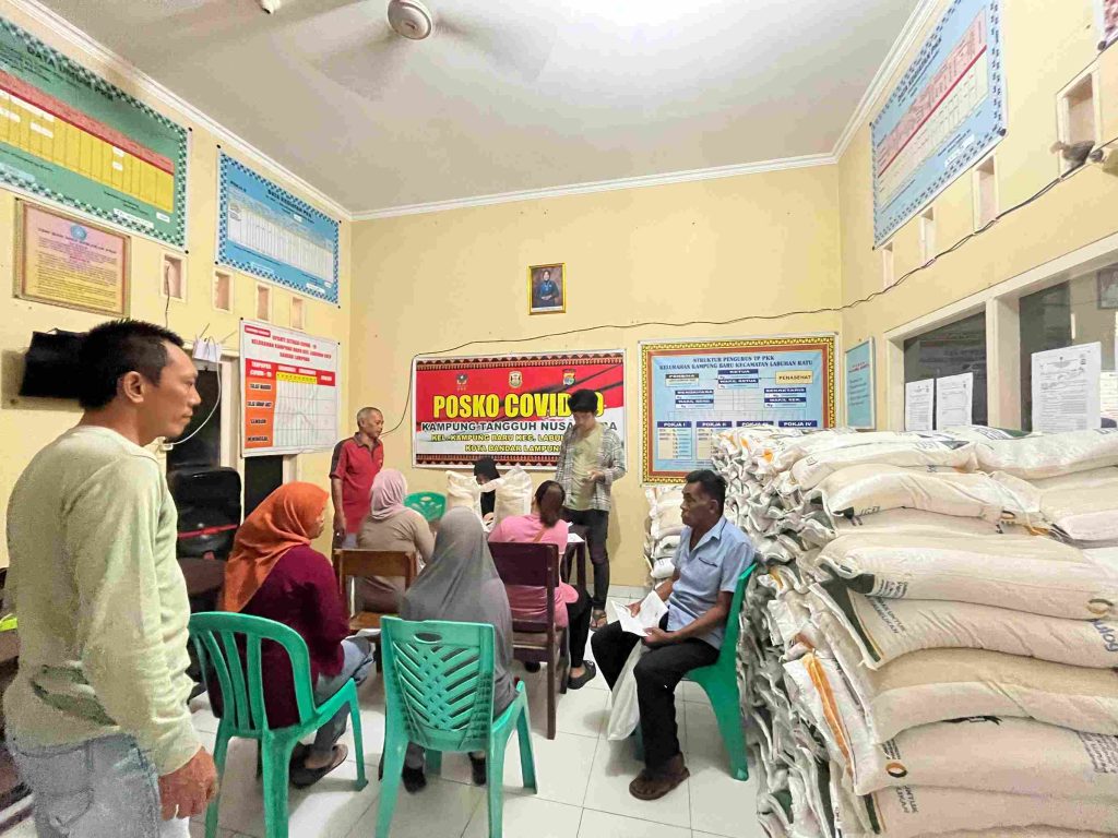 Mahasiswa KKN Kampung Baru membantu perangkat kelurahan dalam pendataan penerima bantuan beras sosial.