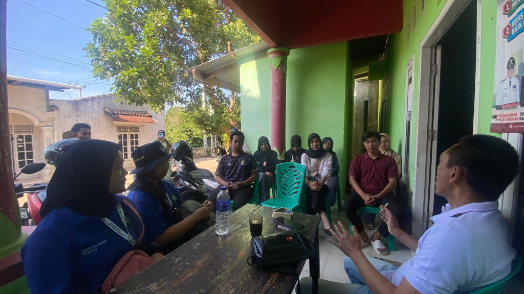 Mahasiswa KKN UIN RIL duduk bersama di teras kantor kelurahan Kampung Baru, berdiskusi dengan bapak lurah mengenai program kerja KKN.