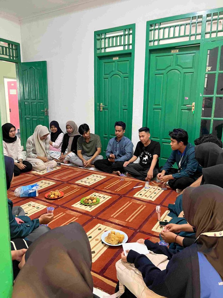 Mahasiswa KKN UNILA dan UIN RIL duduk bersama di Posko UIN RIL pada 18 Juli 2025, berdiskusi mengenai rencana program kerja (PROGJA) yang akan dijalankan selama pengabdian di Kelurahan Kampung Baru.