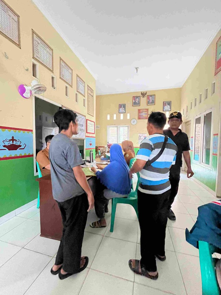 Mahasiswa KKN membantu pelayanan administrasi masyarakat di Kantor Kelurahan Kampung Baru bersama perangkat kelurahan.